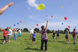 Balloons in 3 colours fly into the sky at a festival celebration